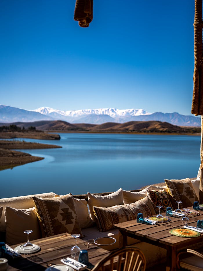 services-01 Scenic outdoor dining area overlooking a lake with mountains in the background.